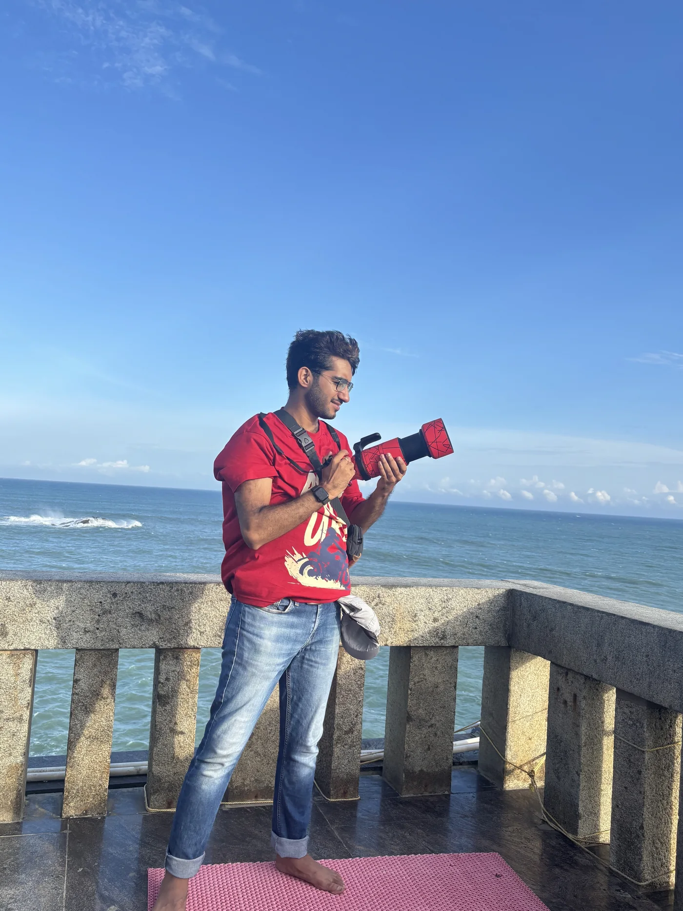Aayush Ahuja holding his camera by the sea