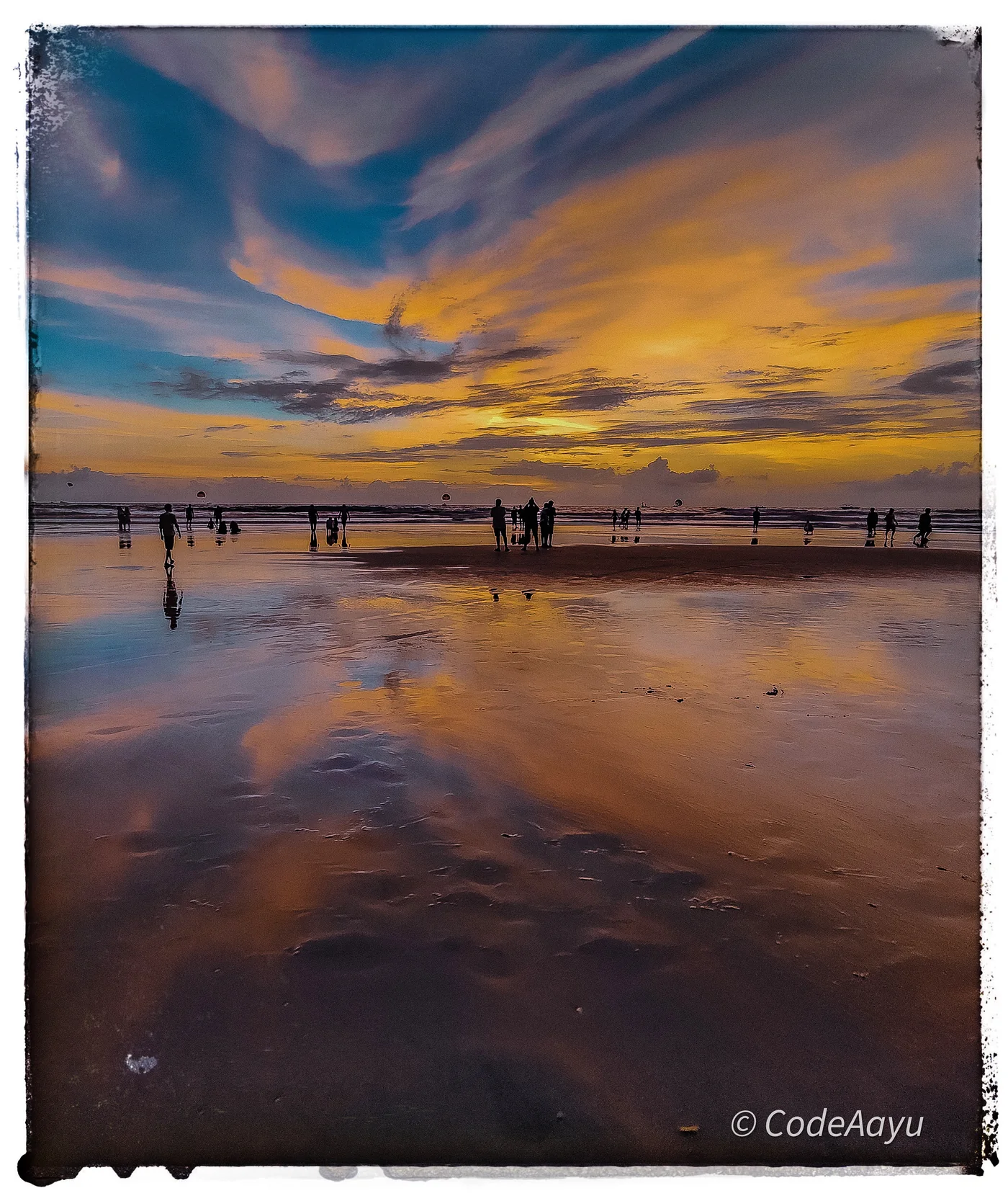 People reflected in a glowing beach sunset
