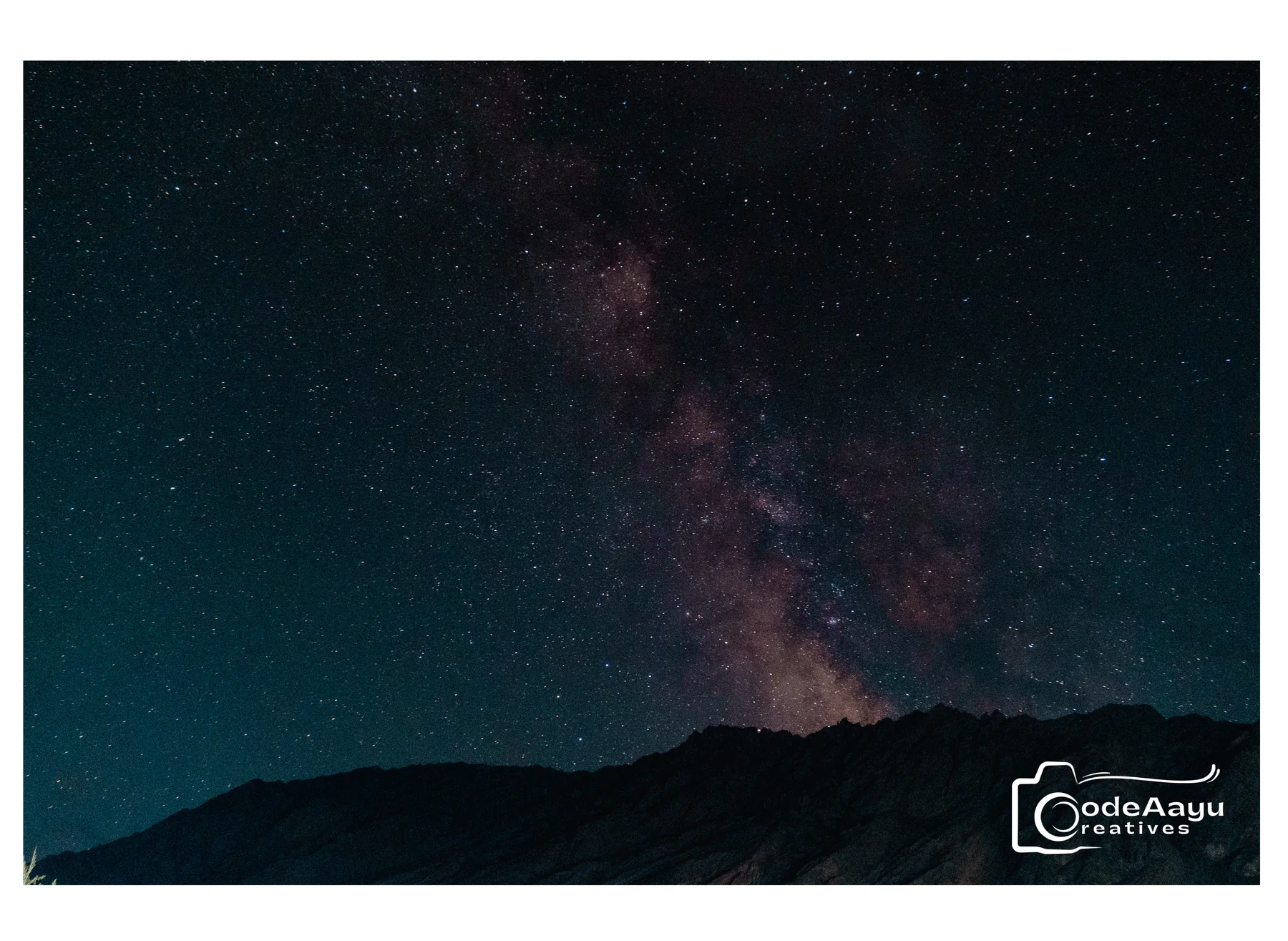 Milky Way rising above a dark mountain silhouette