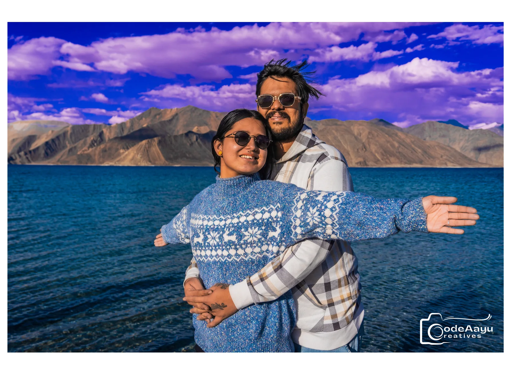 Happy couple by a blue mountain lake